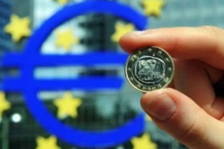Moeda de um euro fotografada ao lado do Banco Central Europeu, em Frankfurt: ajuda financeira à Grécia quer defender a moeda que uniu os países.  (.)
