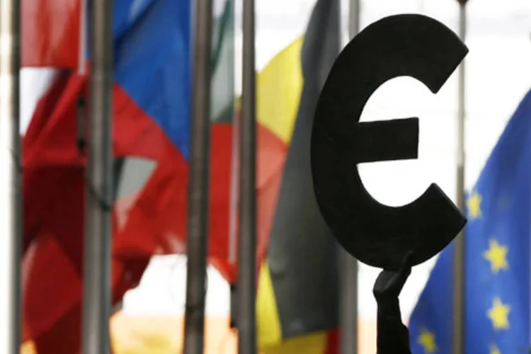 
	Est&aacute;tua representando o euro pr&oacute;xima a bandeiras dos pa&iacute;ses membros da Uni&atilde;o Europeia em Bruxelas, na B&eacute;lgica
 (Reuters/ Francois Lenoir)