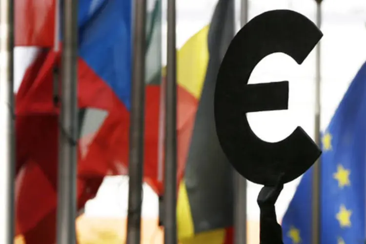 
	Est&aacute;tua representando o euro pr&oacute;xima a bandeiras dos pa&iacute;ses membros da Uni&atilde;o Europeia em Bruxelas, na B&eacute;lgica
 (Reuters/ Francois Lenoir)