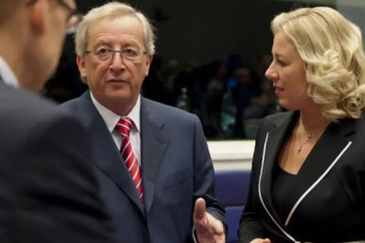 Chefe dos ministros da zona do euro, Jean-Claude Juncker (E), com ministra finlandesa das Finanças, Jutta Urpilainen (R) (Jean-Christophe Verhaegen/AFP)