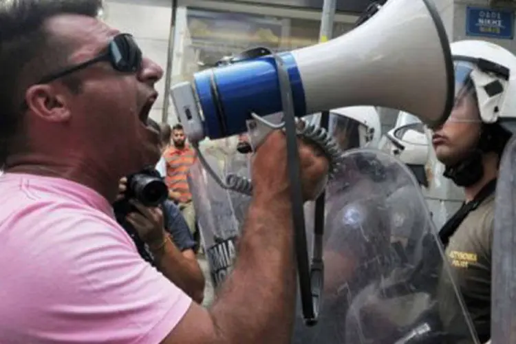 
	Protesto de trabalhadores gregos: greve pode coincidir com uma esperada vota&ccedil;&atilde;o parlamentar sobre as pol&iacute;ticas acordadas entre Atenas e a Uni&atilde;o Europeia e os credores do FMI&nbsp;
 (Louisa Gouliamaki/AFP)