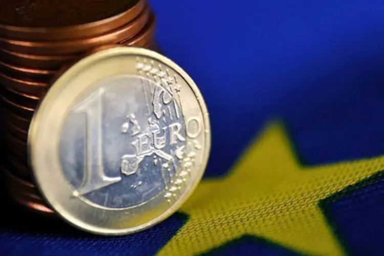 
	Moedas de euro sobre a bandeira da Uni&atilde;o Europeia: segundo economista, os resultados deixam entrever uma poss&iacute;vel atenua&ccedil;&atilde;o da recess&atilde;o atravessada pela Eurozona
 (©afp.com / Philippe Huguen)