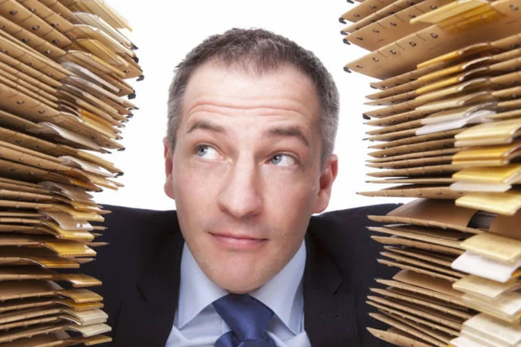 
	Executivo olha para pilha de pap&eacute;is: menos inspira&ccedil;&atilde;o e mais transpira&ccedil;&atilde;o
 (Thinkstock/Dieter Meyrl)