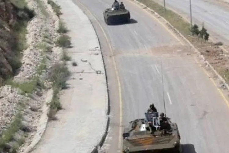
	Tanques do ex&eacute;rcito s&iacute;rio deixam Deraa pela estrada: o Ex&eacute;rcito s&iacute;rio enviou dezenas de tanques e de soldados ao acampamento
 (Louai Beshara/AFP)
