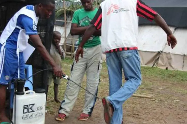 Homem passa por desinfecção antes de entrar em centro de saúde da ONG Médicos sem Fronteiras (MSF), em Lokolia, República Democrática do Congo (Kathy Katayi/AFP)