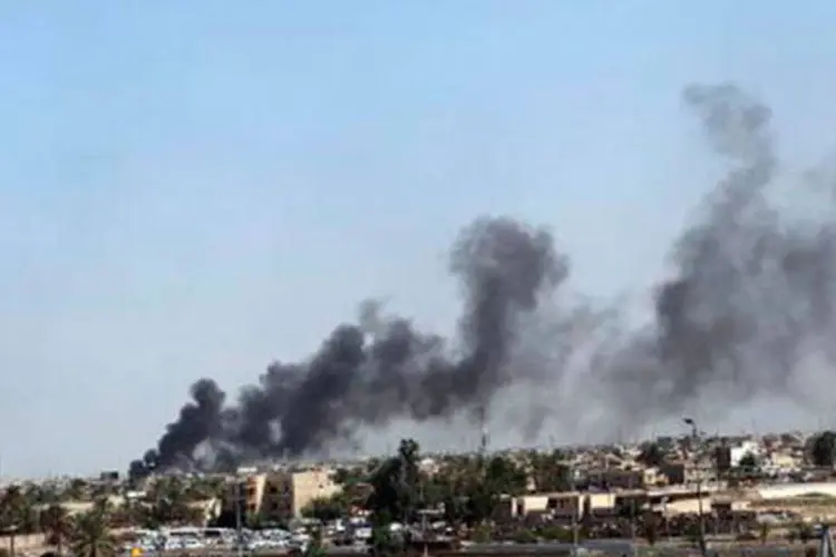 
	Fuma&ccedil;a sai do lugar onde um carro explodiu em Bagd&aacute;, no Iraque: quatro ve&iacute;culos explodiram de forma quase consecutiva
 (AFP)