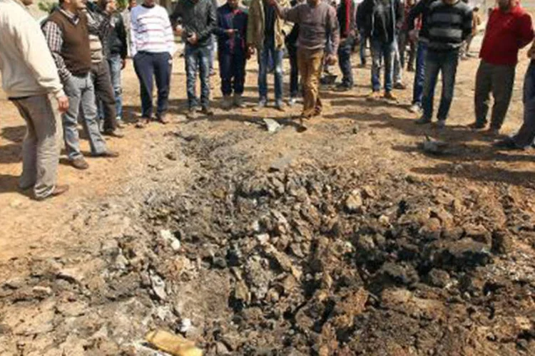 
	Pessoas observam local de explos&atilde;o em Benghazi: &nbsp;suspeito est&aacute; sendo mantido em local seguro fora do territ&oacute;rio l&iacute;bio
 (Abdullah Doma/AFP)
