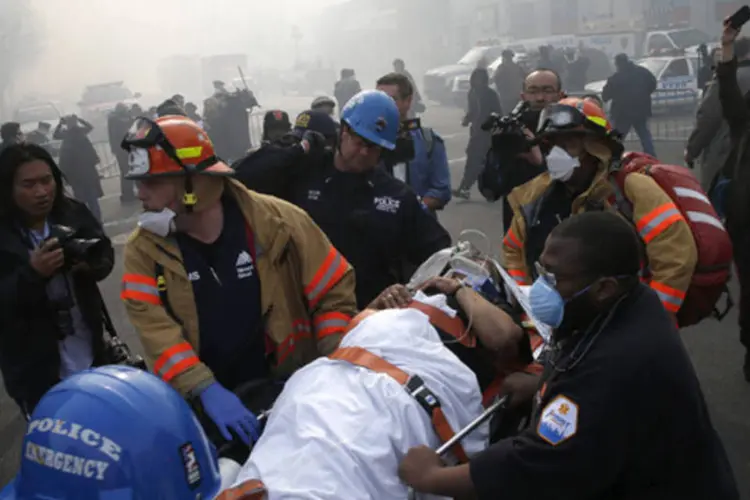 Uma vítima é evacuada por uma equipe de resgate perto do local do desabamento de prédios no Harlem, na cidade de Nova York (Mike Segar/Reuters)