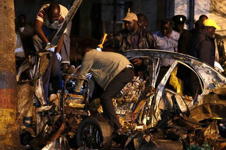 Policial queniano recolhe o corpo de uma das vítimas da explosão de um carro-bomba em um bairro pobre de Nairóbi, capital do Quênia (Thomas Mukoya/Reuters)