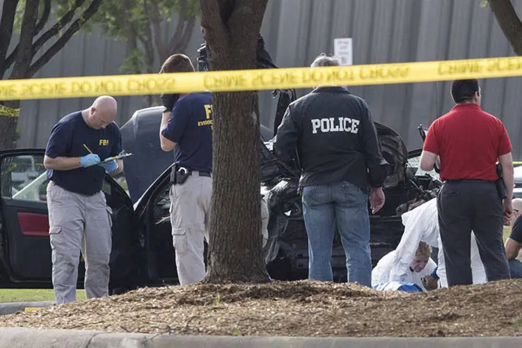 Investigadores da polícia e do FBI fazem buscas na área em torno do carro usado por atiradores que dispararam durante exposição em Garland, no Texas (REUTERS/Laura Buckman)