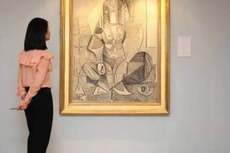 Mulher observa quadro de Pablo Picasso: o espanhol introduziu na arte novas concepções revolucionárias que originaram o cubismo, movimento criado por ele e George Braque (Ed Jones/AFP)