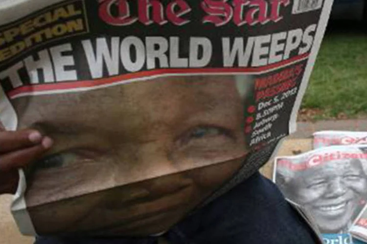 Homem lê jornal em Soweto com a primeira página consagrada a Nelson Mandela (Alexander Joe/AFP)