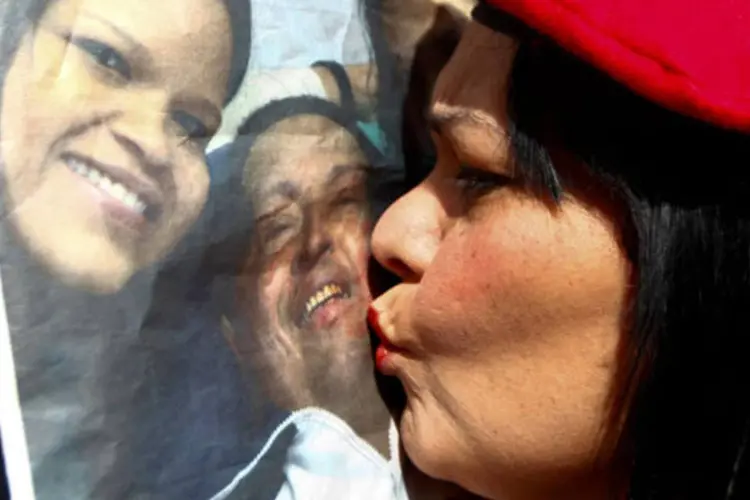 Partidária de Hugo Chávez beija foto de líder venezuelano (REUTERS/Carlos Garcia Rawlins)