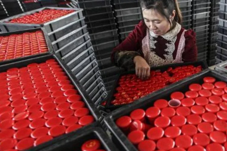 Mulher trabalhando em fábrica de Lianyungang, China: país investirá no exterior do que recebe de investimentos estrangeiros (STR/AFP)