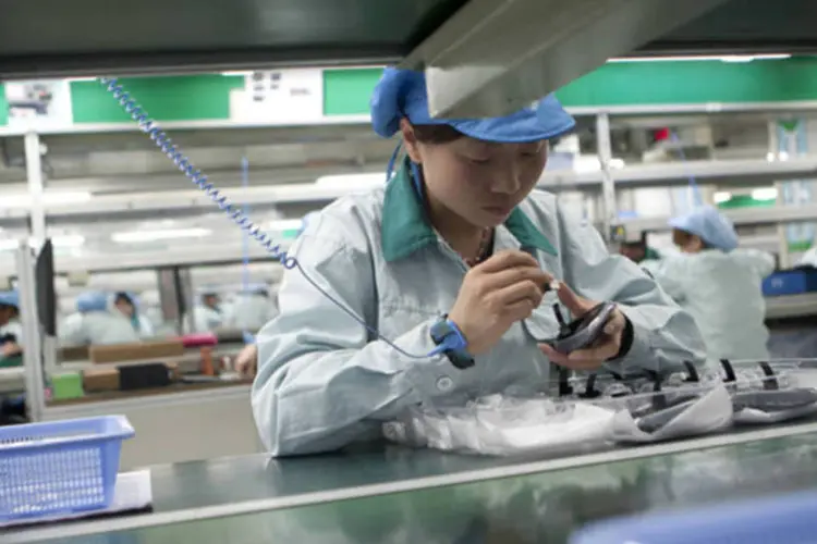 Mulher trabalha na linha de montagem de mouses da Logitech em uma fábrica em Suzhou, província de Jiangsu, na China (Nelson Ching/Bloomberg/Bloomberg)
