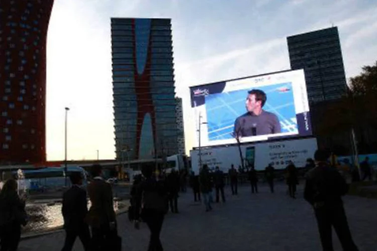 Visitantes acompanham em telão palestra de Mark Zuckerberg no Congresso Mundial de Telefonia Móvel de Barcelona: plataforma só cobra se a publicidade for eficaz (AFP)