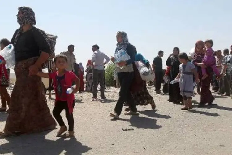 Famílias da comunidade yazidi cruzam a fronteira com a Síria (Ahmad Al Rubaye/AFP)