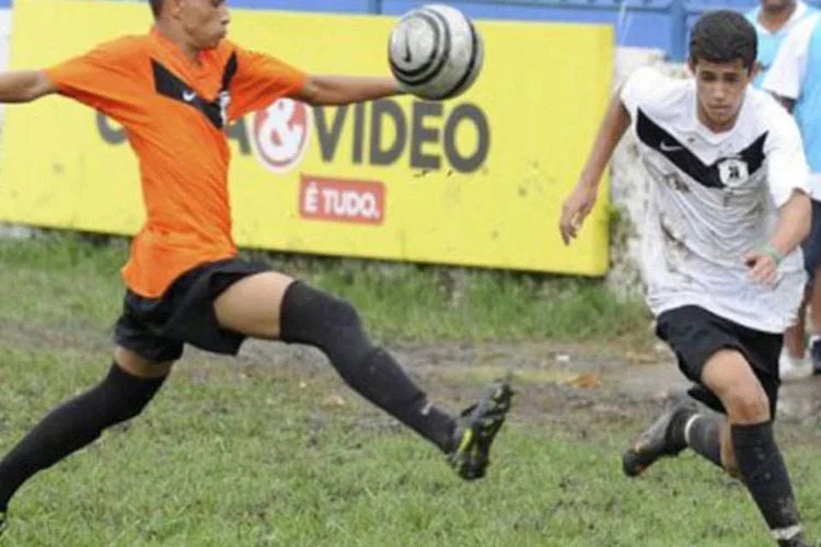 Jovens apaixonados por futebol em favelas do Rio: grandes clubes enviam olheiros a cada jogo do torneio para ver o desempenho de cada jogador e escolher possíveis promessas. (©afp.com / Antonio Scorza)