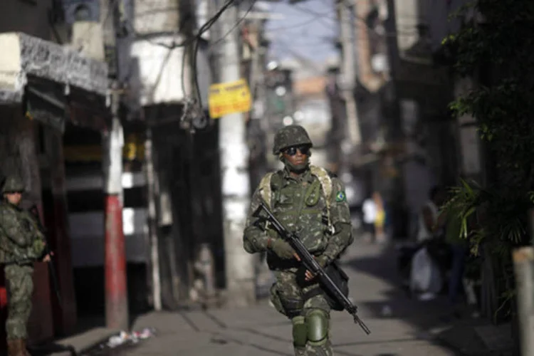 
	Soldado do Ex&eacute;rcito brasileiro patrulha as ruas do complexo da Mar&eacute; durante a ocupa&ccedil;&atilde;o, no Rio: a v&iacute;tima, de 20 anos, morreu em uma suposta troca de tiros com soldados
 (Ricardo Moraes/Reuters)