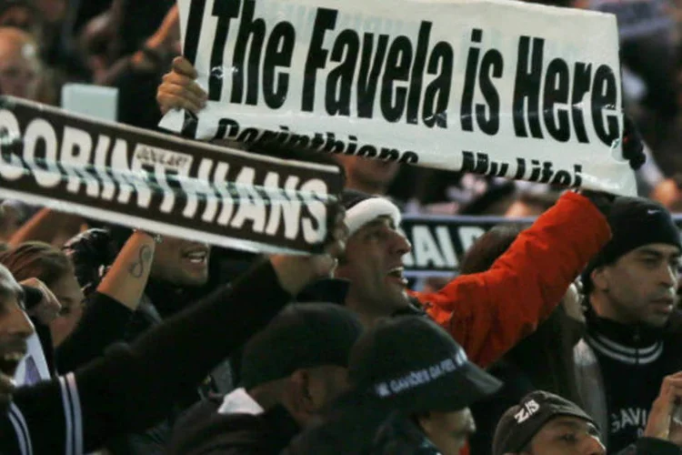 
	Torcedor do Corinthians segura cartaz com os dizeres &quot;A favela &eacute; aqui&quot;, durante a final
 (REUTERS/Toru Hanai)