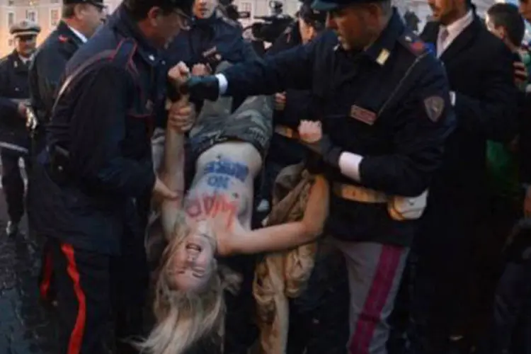 Ativista do Femen é detida por policiais, a poucos metros da Praça de São Pedro: as integrantes do Femen ficaram conhecidas em 2010 por suas ações de "topless" na Rússia, na Ucrânia e em Londres. (©afp.com / Gabriel Bouys)