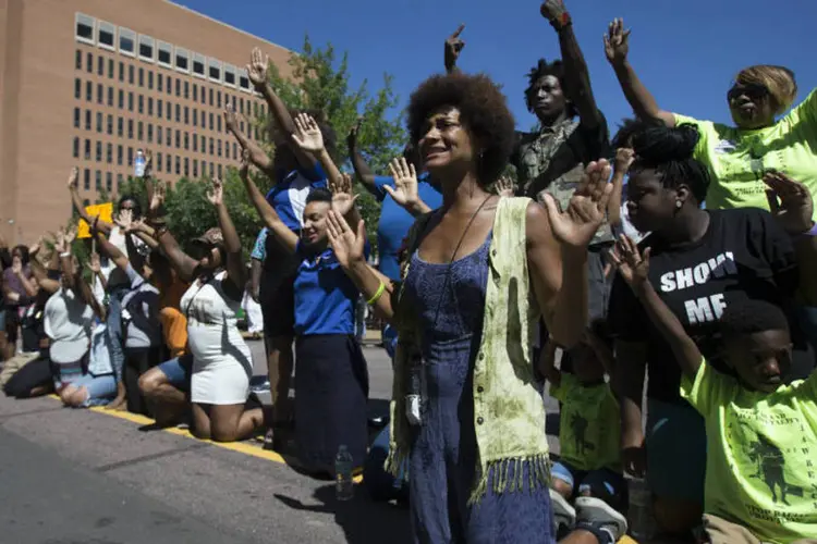 
	Manifestantes levantam as m&atilde;os enquanto protestavam contra a morte de adolescente negro Michael Brown, em Ferguson, EUA
 (REUTERS/Mario Anzuoni)