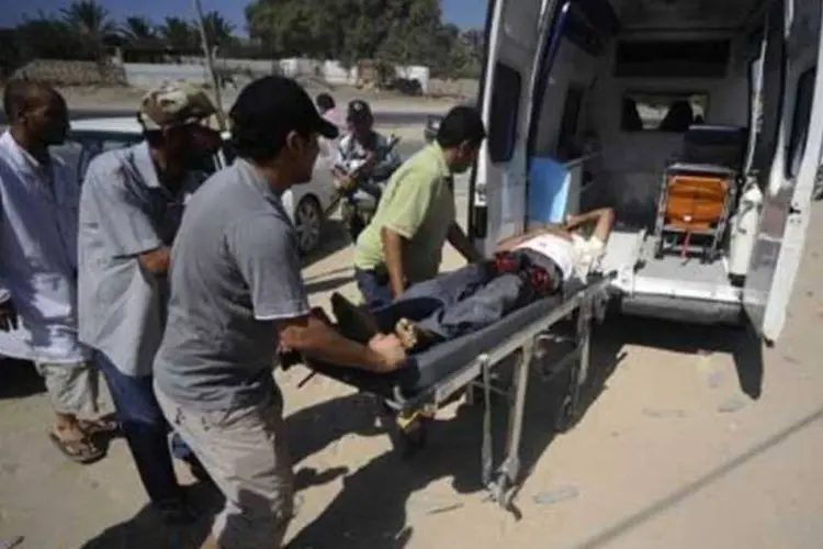 Um rebelde ferido é colocado em uma ambulância em Gadayem (Filippo Monteforte/AFP)