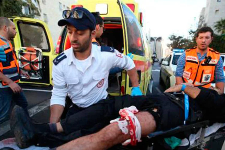 Homem israelense ferido após ataque a sinagoga no bairro de Har Nof é levado para ambulância em 18 de novembro de 2014
 (MIRI TSACHIE/AFP)