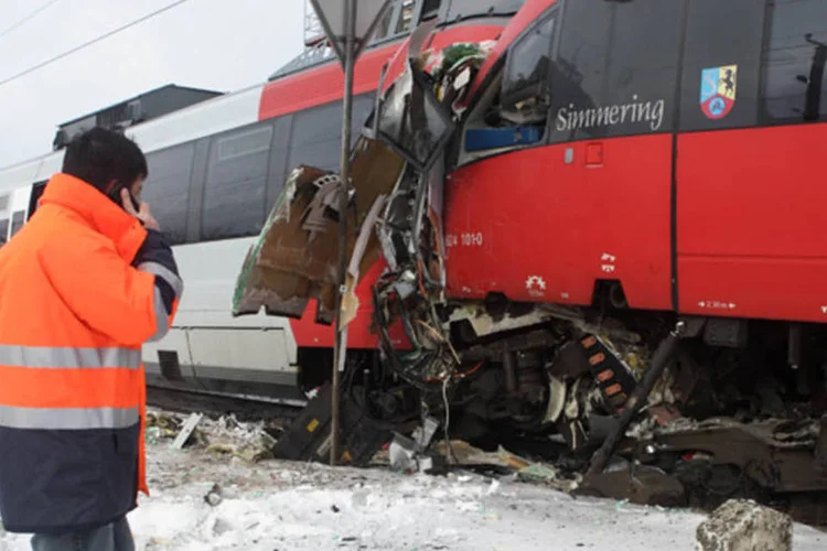 Funcionário ferroviário fala ao telefone em frente aos destroços dos trens S45 após choque em Viena, na Austria (Heinz-Peter Bader/Reuters)