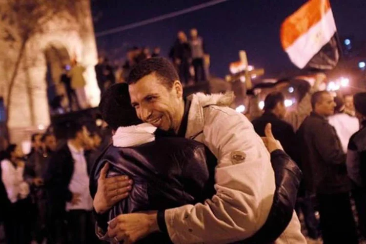 Cidadãos se abraçam na praça Tahrir e festejam a queda de Hosni Mubarak (Getty Images)