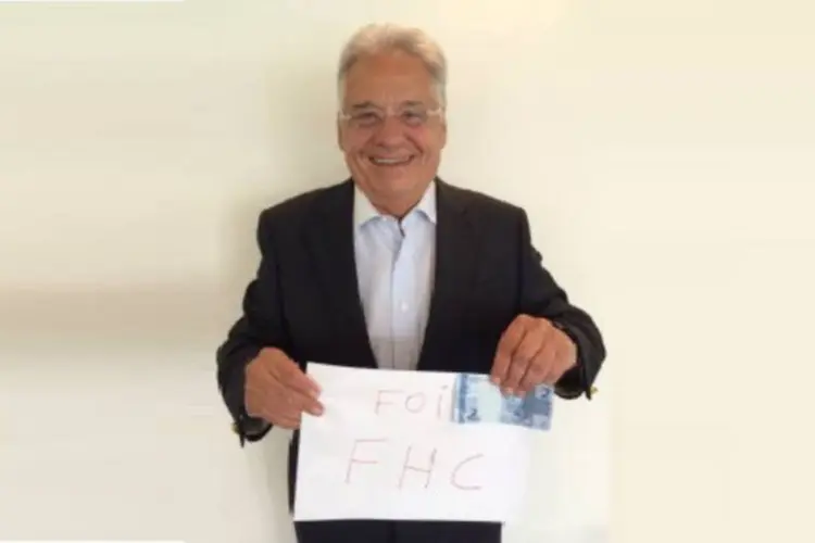 Fernando Henrique Cardoso segura placa e nota de dinheiro em referência ao Plano Real, dizendo que "Foi FHC" (Reprodução/PSDB)
