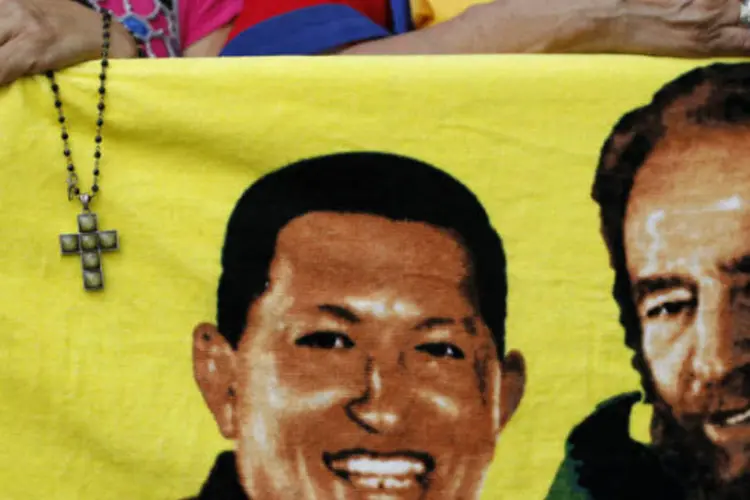 
	Apoiadores de Ch&aacute;vez carregam bandeira com imagem do presidente venezuelano ao lado de Fidel Castro: h&aacute; mais de um m&ecirc;s, Ch&aacute;vez n&atilde;o &eacute; visto em p&uacute;blico
 (REUTERS/Carlos Garcia Rawlins)