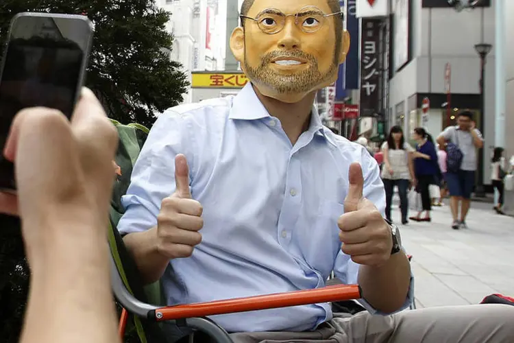 Homem com máscara de Steve Jobs aguarda o lançamento do novo iPhone em frente a uma Apple Store de Ginza, no Japão (Yuya Shino/Reuters)