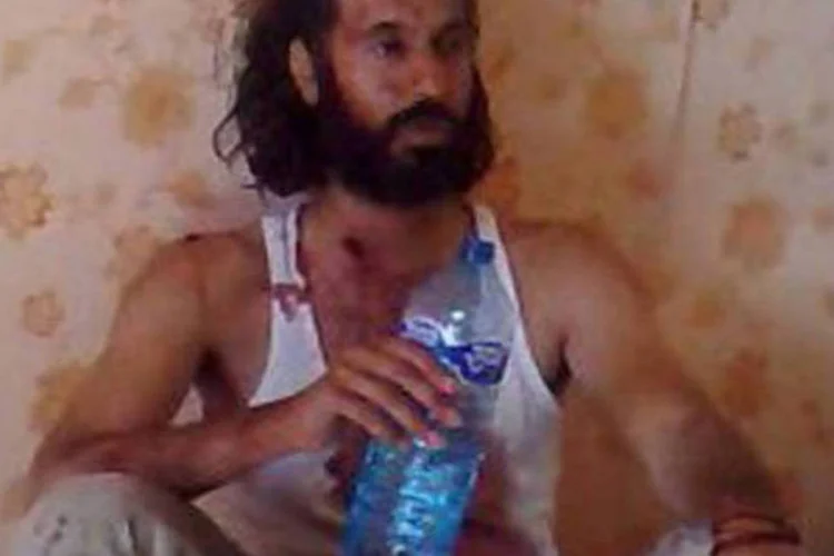 Imagem captada de um vídeio de Muatasim Kadafi bebendo água antes de ser morto em Sirte, ao lado do pai
 (AFP)
