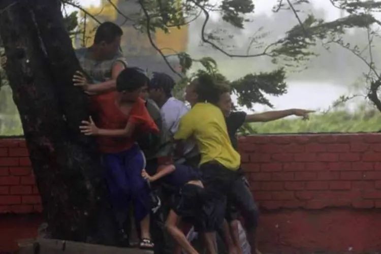 Pessoas tentam se proteger dos ventos furiosos do tufão Rammasun nas Filipinas  (REUTERS)