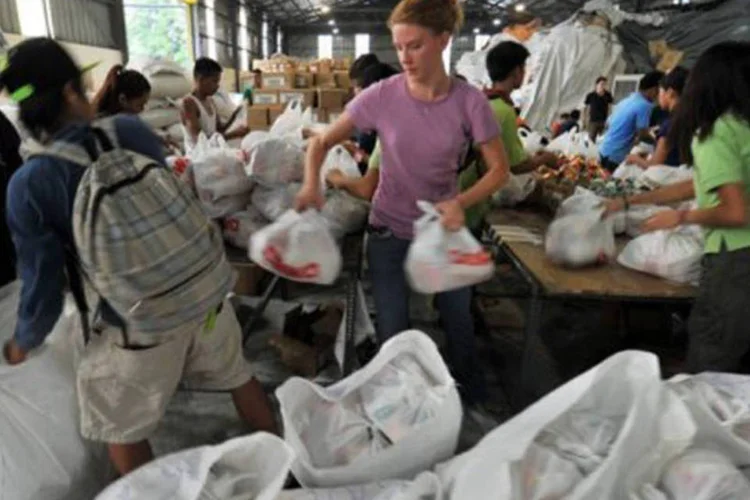 
	Volunt&aacute;rios separam doa&ccedil;&otilde;es para v&iacute;timas de inunda&ccedil;&otilde;es em Manila: as enchentes nessa regi&atilde;o foram consequ&ecirc;ncia de chuvas intermitentes
 (Ted Aljibe/AFP)