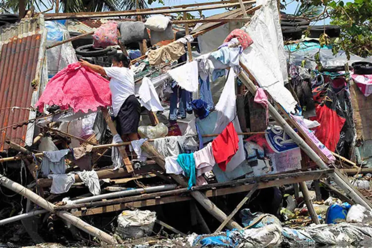 Roupas estendidas em casa destruída após passagem de tufão nas Filipinas (REUTERS/Romeo Ranoco)