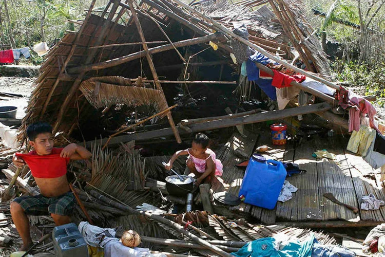 Crianças em meio à destruição causada por tufão nas Filipinas (REUTERS/Erik De Castro)