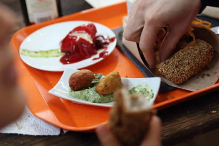 Pessoas comem peixe frito: as pessoas devem se limitar a ingerir até dois gramas de gordura trans por dia, de acordo com a Associação Americana de Cardiologia. (GettyImages)