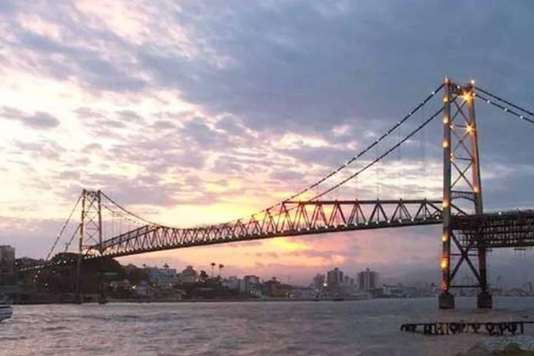 Com o pôr do sol do fim da tarde, a Ponte Hercílio Luz rende ótimos cliques (Wikimedia Commons)