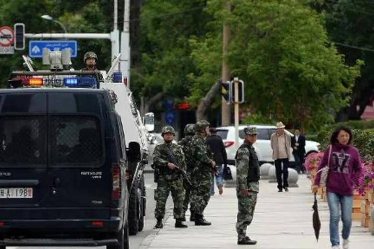 Força paramilitar chinesa em rua de Xinjiang: explosões aconteceram em 3 locais (Goh Chai Hin/AFP)