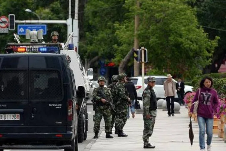 Força paramilitar chinesa em rua de Xinjiang: explosões aconteceram em 3 locais (Goh Chai Hin/AFP)