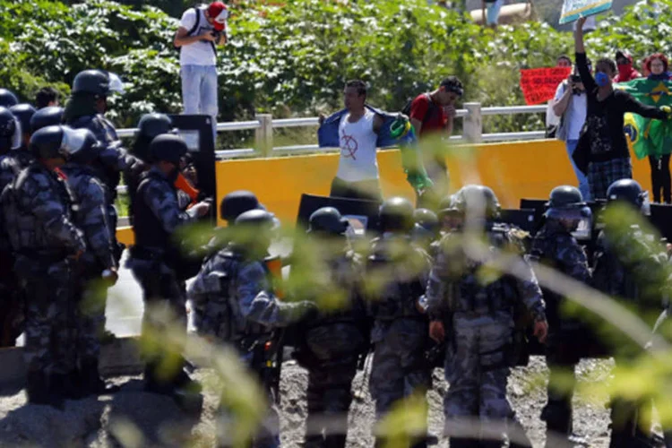 A Polícia conteve nesta quarta-feira um grande número de pessoas que protestam aos arredores do estádio do Castelão, em Fortaleza: devido às manifestações, os torcedores e jornalistas que se dirigiam ao estádio foram desviados a ruas alternativas. (REUTERS/Kai Pfaffenbach)