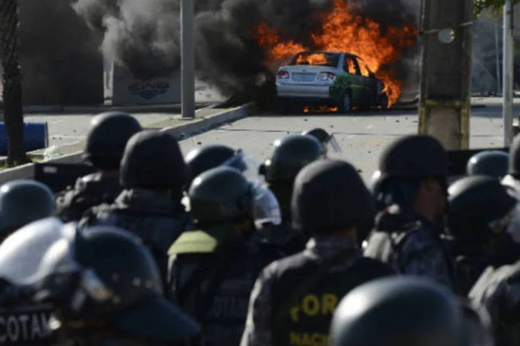
	Ve&iacute;culo &eacute; incendiado pr&oacute;ximo &agrave; guarda da Pol&iacute;cia durante protesto nas proximidades do est&aacute;dio do Castel&atilde;o, em Fortaleza
 (REUTERS/Davi Pinheiro)