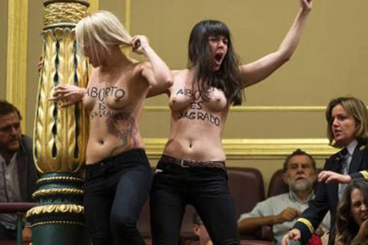 Integrantes do grupo feminista Femen invadem uma sessão do Parlamento de Madri: alguns deputados da oposição aplaudiram a ação (Dani Pozo/AFP)