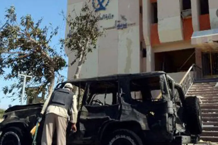 Policial egípcio inspeciona carro destruído por atentado: desconhecido colidiu seu carro cheio de explosivos contra um posto de controle militar (Mohamed El-Shamed/AFP)