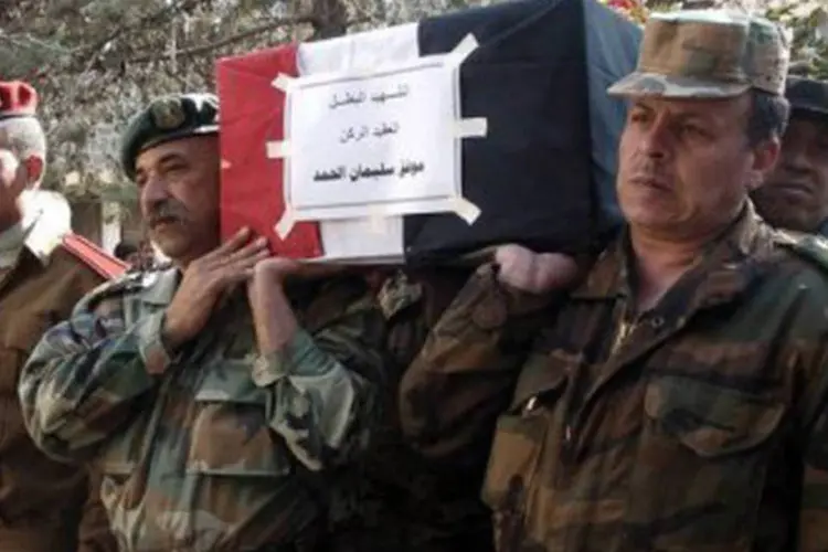 Foto divulgada pela agência oficial síria Sana mostra o funeral de um soldado
 (SANA/AFP)