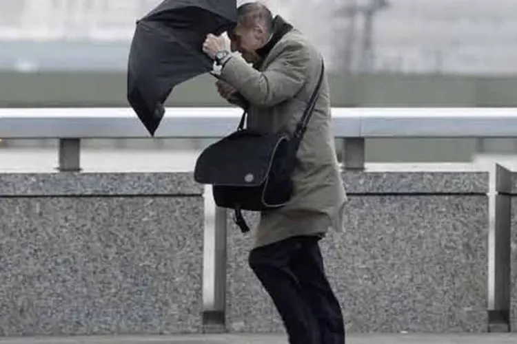 
	Pedestre perde o controle de seu guarda-chuva em Londres: autoridades indicaram que 7.500 casas na Inglaterra e Gales n&atilde;o t&ecirc;m eletricidade
 (REUTERS)