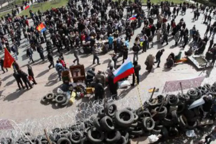 
	Ativistas pr&oacute;-russos se protegem atr&aacute;s de barricadas em Donetsk: l&iacute;der&nbsp;pediu que seus seguidores pr&oacute;-R&uacute;ssia&nbsp;tomem o controle dos organismos p&uacute;blicos
 (Alexander Khudoteply/AFP)