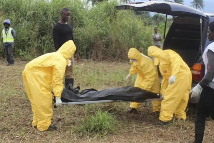 
	Agentes carregam corpo de v&iacute;tima do ebola: a epidemia j&aacute; dura um ano
 (Josephus Olu-Mamma/Reutersagentes-ebola)